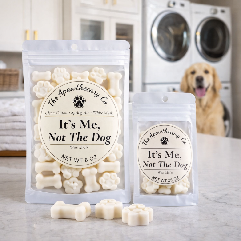 Two packages of 'It's Me, Not The Dog' wax melts with a dog in the background.