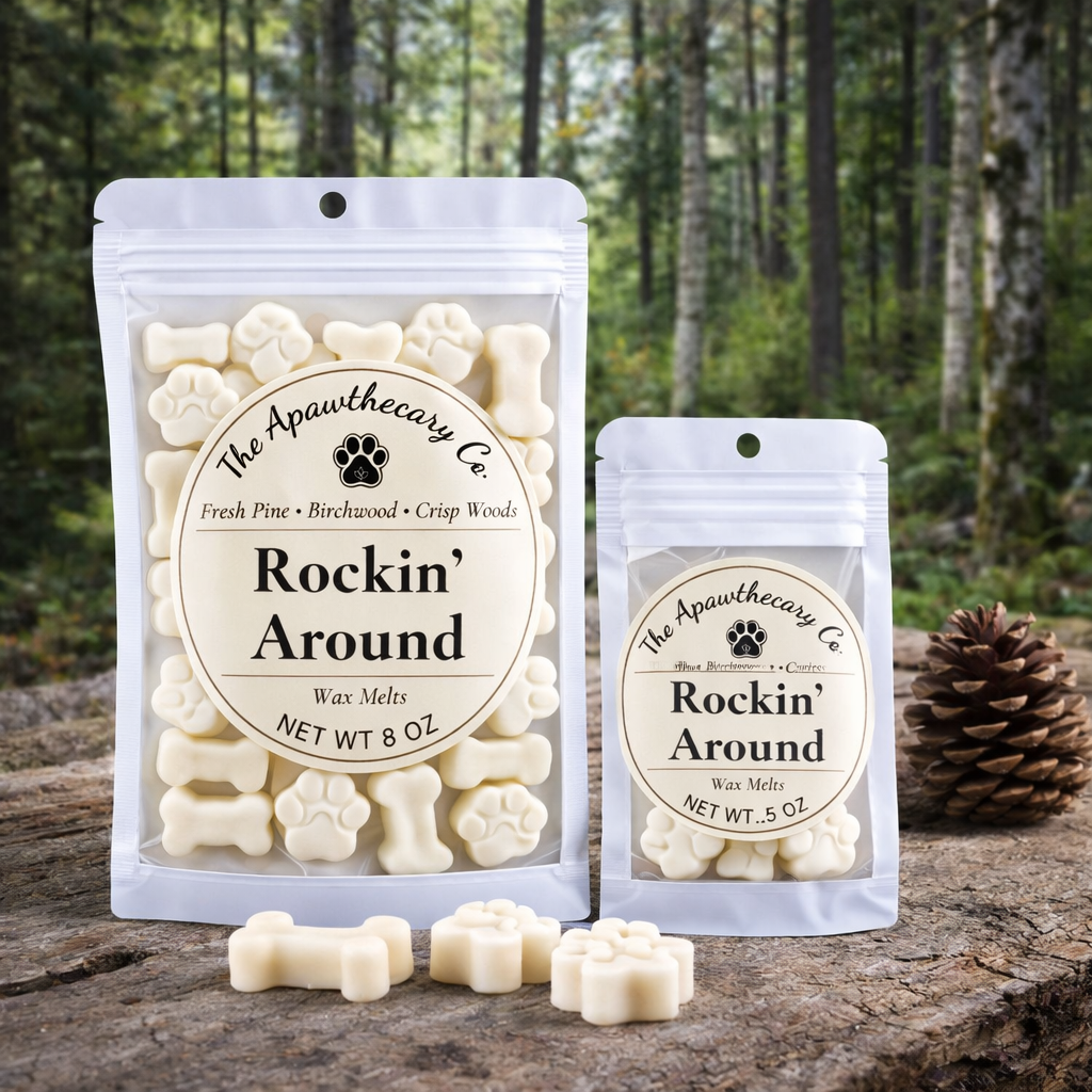 Two packages of 'Rockin' Around' wax melts from The Apawthecary Co. on a wooden surface with a forest background.