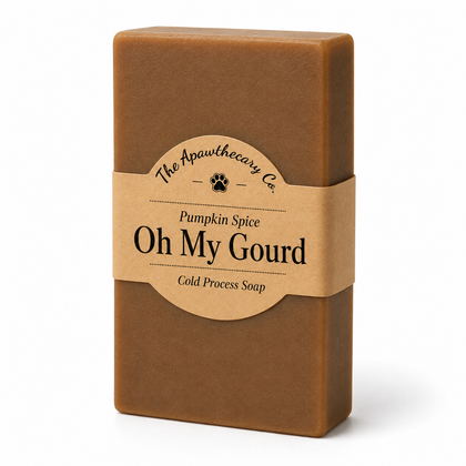 A rectangular bar of brown soap wrapped with a kraft paper label that reads 'The Apawthecary Co. Oh My Gourd Pumpkin Spice Cold Process Soap' on a white background.
