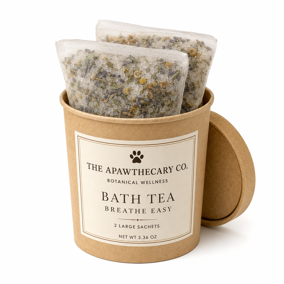 Two large bath tea sachets visible inside a kraft paper cylindrical container with the lid leaning against it. The front label reads 'THE APAWTHECARY CO.
