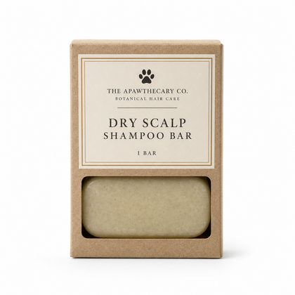The Apawthecary Co. Dry Scalp Shampoo Bar in its kraft paper packaging, showing the beige bar through a clear window on a white background.