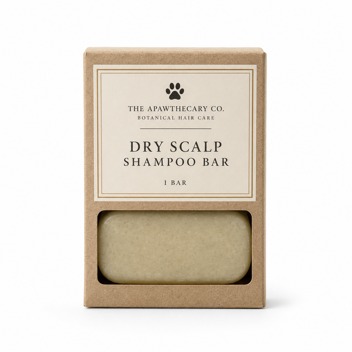 The Apawthecary Co. Dry Scalp Shampoo Bar in its kraft paper packaging, showing the beige bar through a clear window on a white background.