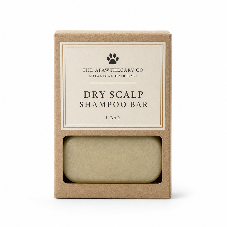The Apawthecary Co. Dry Scalp Shampoo Bar in its kraft paper packaging, showing the beige bar through a clear window on a white background.