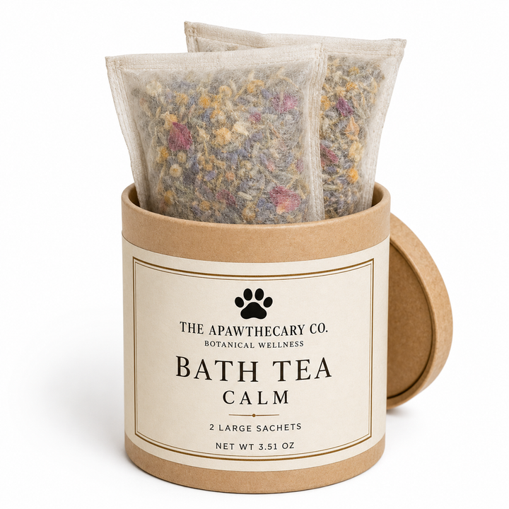 Two large bath tea sachets filled with dried botanicals, displayed inside a round kraft paper container labeled 'The Apawthecary Co. Bath Tea Calm' on a white background.