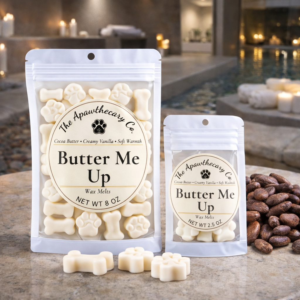 Two packages of 'Butter Me Up' wax melts from The Apawthecary Co. on a table with a blurred background.