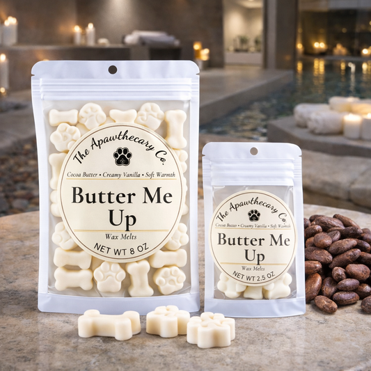 Two packages of 'Butter Me Up' wax melts from The Apawthecary Co. on a table with a blurred background.