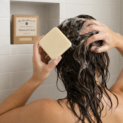 Person washing their hair with the Balanced Clean shampoo bar in a tiled shower.
