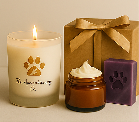 Candle, jar of cream, and soap with paw print design next to a gift box on a beige background.
