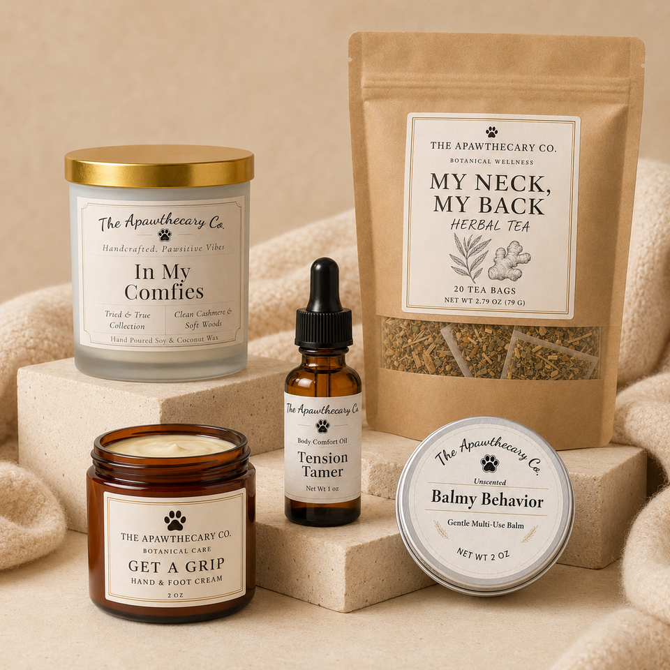 A curated wellness gift set from The Apawthecary Co. arranged on beige stone blocks and soft fabric.