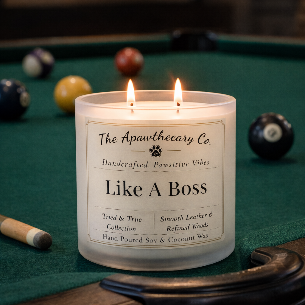 Candle labeled 'Like A Boss' from The Apawthecary Co. on a pool table with pool balls.