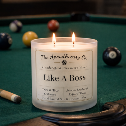 Candle labeled 'Like A Boss' from The Apawthecary Co. on a pool table with pool balls.