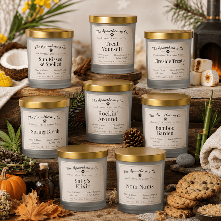 Collection of candles with labels on a rustic wooden surface with decorative items.