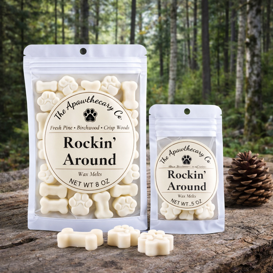 Two packages of 'Rockin' Around' wax melts from The Apawthecary Co. on a wooden surface with a forest background.