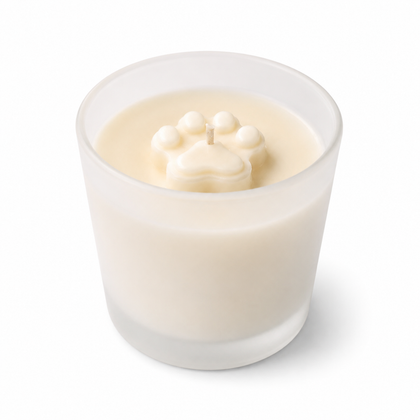 Candle in a glass holder with a paw print design on a white background
