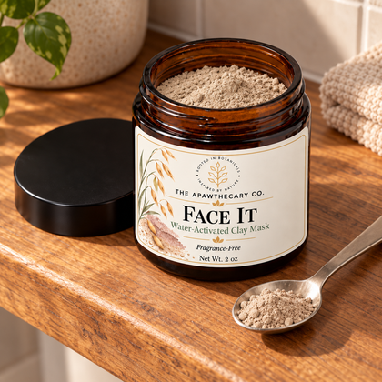 Close-up of dry powder in an open Face It clay mask jar with a spoonful beside it.