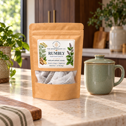 Rumbly herbal tea pouch beside a green lidded mug on a kitchen counter.