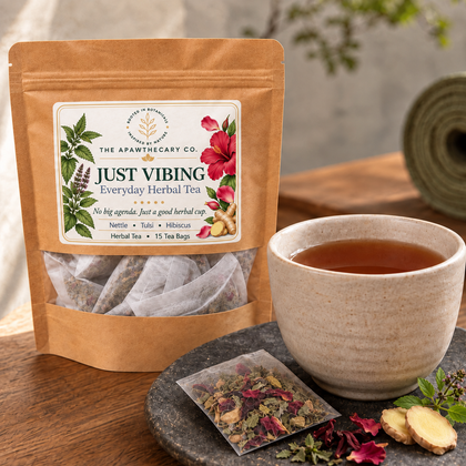 Just Vibing 15-bag herbal tea pouch beside a brewed cup and filled tea sachet.