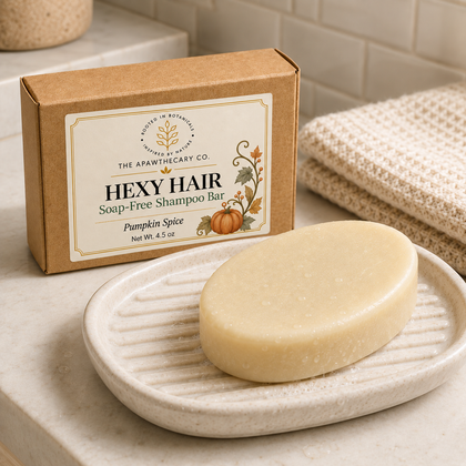 Hexy Hair shampoo bar on a bathroom soap dish beside its kraft package