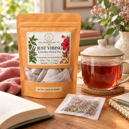 Just Vibing – Everyday Herbal Tea — Just Vibing, a covered steeping cup and one bag at a bright everyday reading table. Palette: sage and dusty rose.