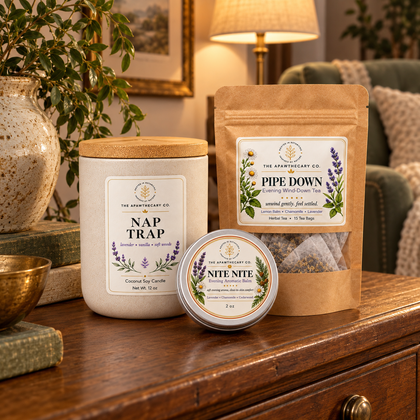 Nap Trap – Evening Wind-Down Trio — Complete exact evening trio on a spacious living-room sideboard, warm lamplight and sage chair distant, all current products visible, any candle closed.