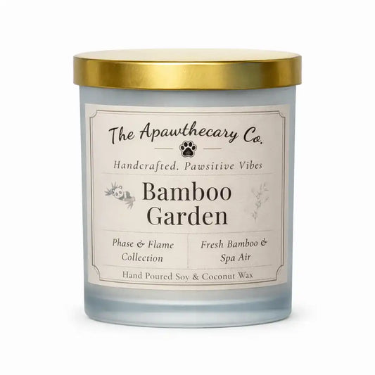 Candle with a gold lid and label from The Apawthecary Co. on a white background