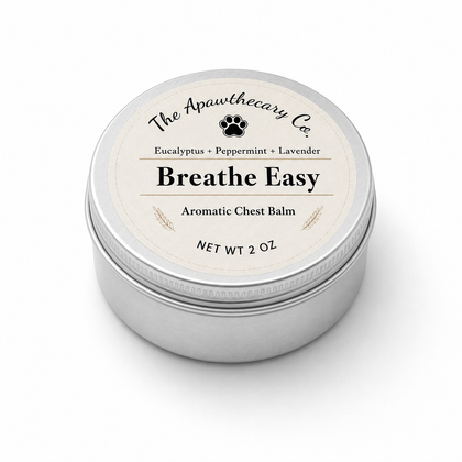 A round silver metal tin of The Apawthecary Co. Breathe Easy Aromatic Chest Balm, featuring a cream-colored label with black text and a small black paw print icon, set against a plain white background.