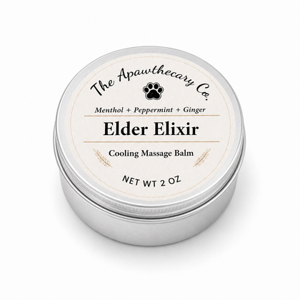A round silver metal tin of 'Elder Elixir' cooling massage balm by 'The Apawthecary Co.' with a cream-colored label, shown on a clean white background.