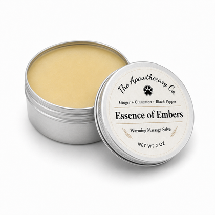 Open 2 oz tin of Essence of Embers warming massage salve with its labeled lid beside it.