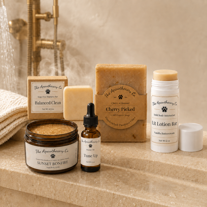 The Everything Shower gift set with Balanced Clean shampoo bar, Cherry Picked soap, Sunset Bonfire scrub, Tune Up oil, and Lit Lotion Bar in a warm shower setting.