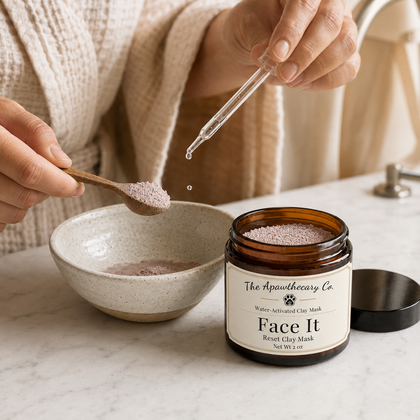 Dropper adding liquid to Face It clay mask powder in a spoon beside the open jar.
