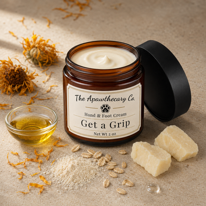 Open jar of Get a Grip cream beside yellow flowers, oats, oil, and solid butter pieces.
