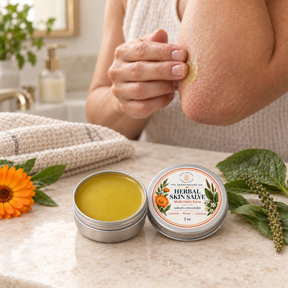 Palm-sized Herbal Skin Salve 2 oz tin beside an adult applying salve to a dry elbow.