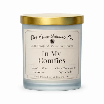 Candle with gold lid and label from The Apawthecary Co. on a white background