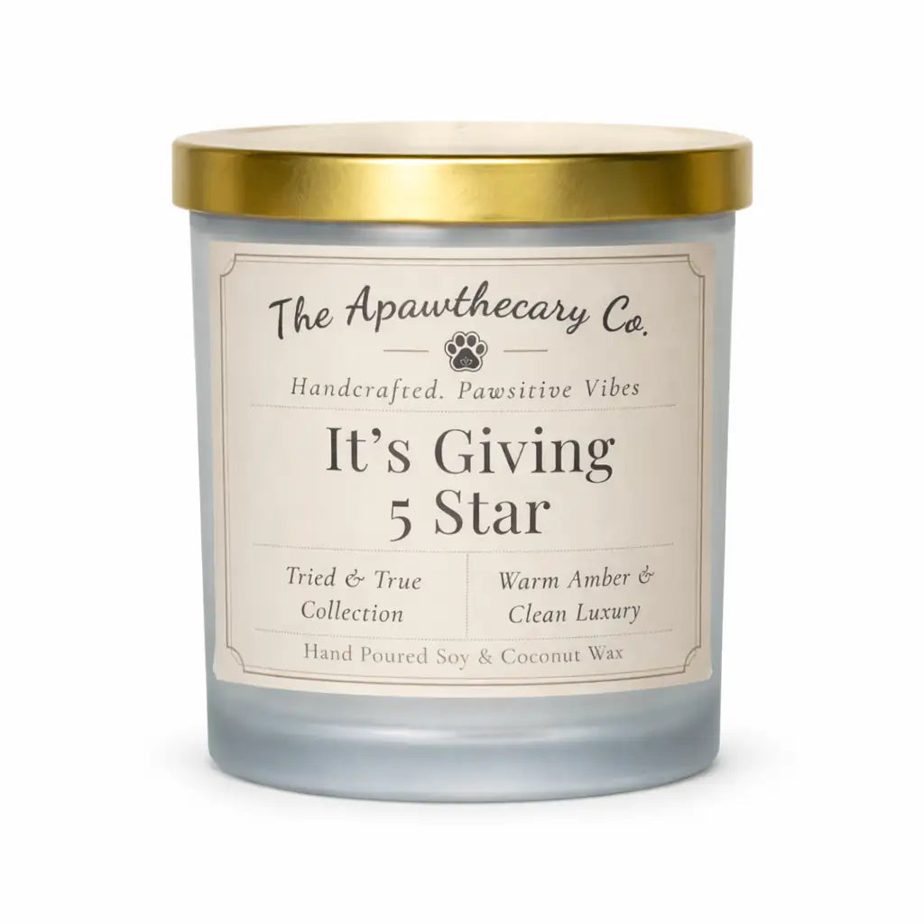 Candle with a gold lid and label from The Apawthecary Co. on a white background