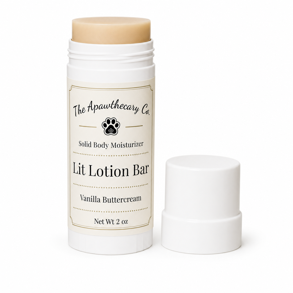 A solid body moisturizer stick by The Apawthecary Co. in Vanilla Buttercream, shown with its white cap removed and placed beside the container on a clean white background.