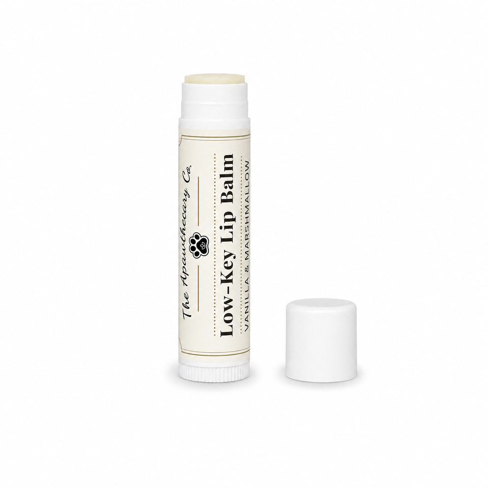 Low-Key Lip Balm tube in vanilla and marshmallow with its cap beside it on a white background.