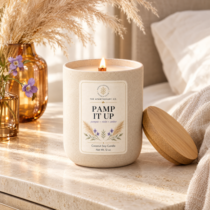 Pamp It Up candle in a soft neutral bedroom setting