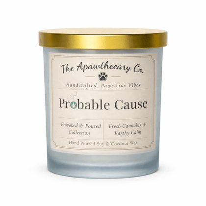 Candle with a gold lid and 'The Apawthecary Co' label on a white background