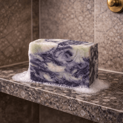 Stormy Nights Cold Process Soap, a calming soap with a unique swirled design and soapy lather on a stone shelf.