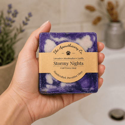 Hand holding a purple soap bar with a label in a bathroom setting