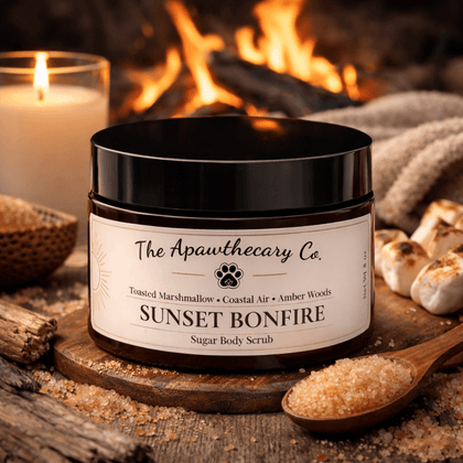 Sunset Bonfire Sugar Body Scrub jar on a wooden table with candles and sugar scrub.