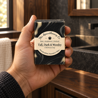 Tall, Dark & Woodsy soap held in a warm charcoal and walnut bathroom