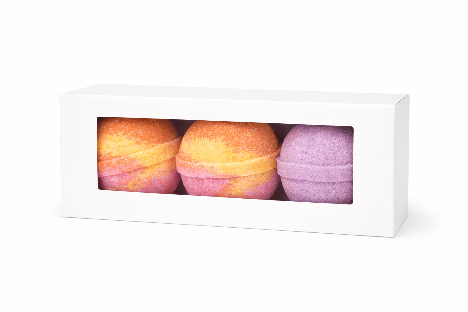 Three bath bombs in a box with a white background