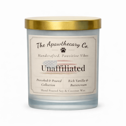 Candle with a gold lid and label from The Apawthecary Co. on a white background